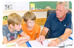 Lehrer mit Kindern beim Individualunterricht im Schultz-Hencke-Haus Kade